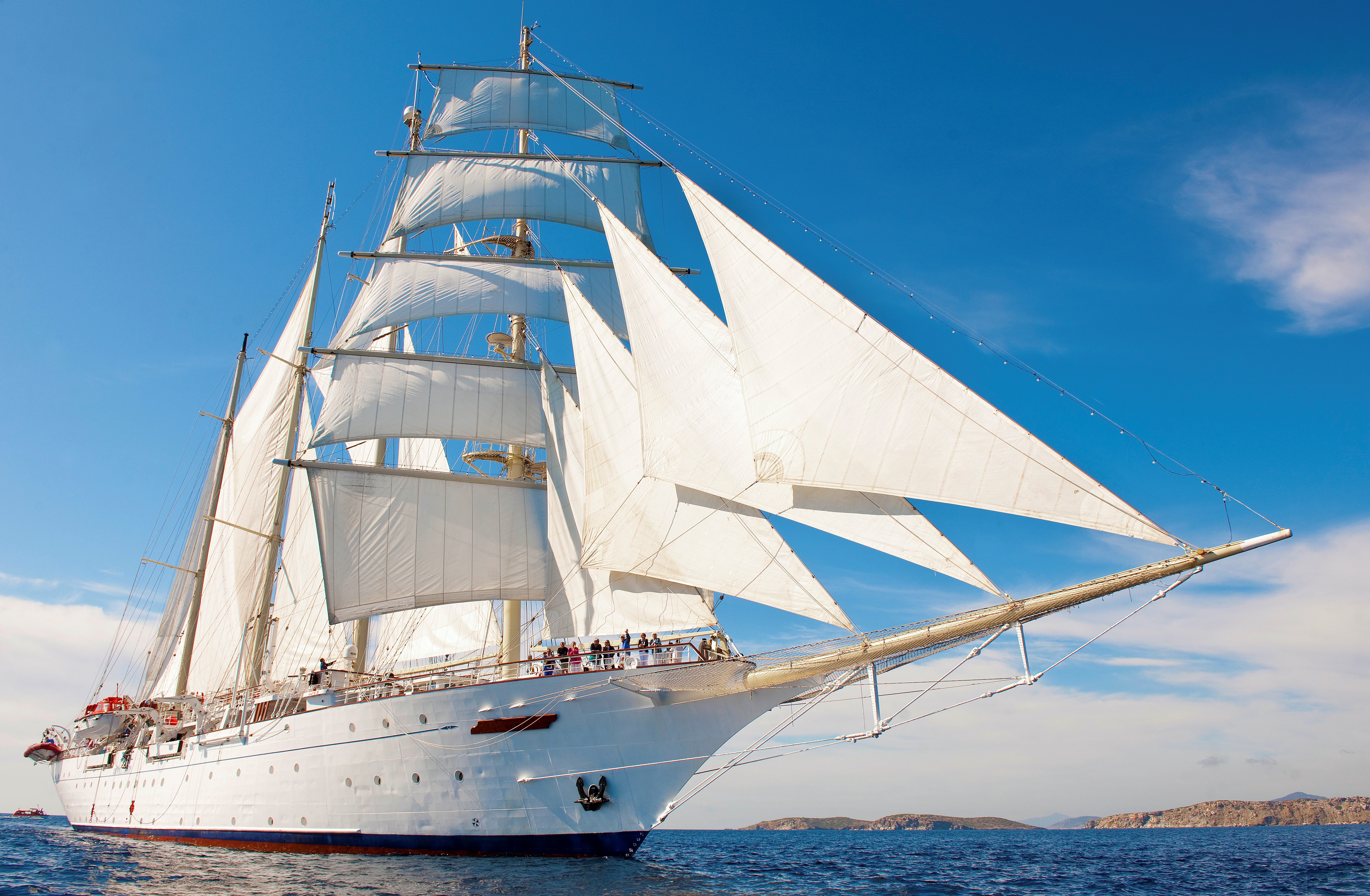 Das Segelschiff Star Clipper auf offenem Meer, rechts davon etwas Land in Sichtt