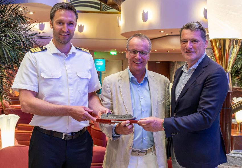 3 Männer halten die Miniaturversion der MSC Magnifica fest
