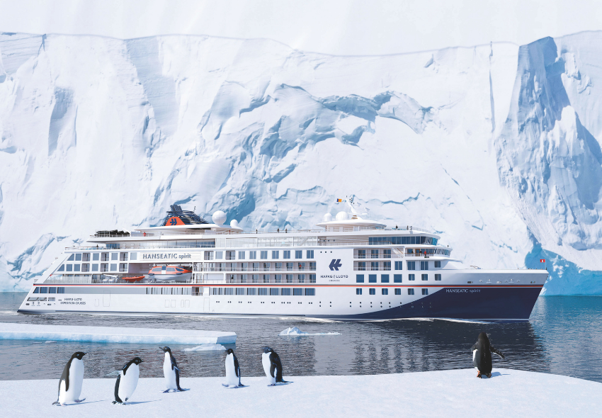 HANSEATIC spirit in den Polarregionen unterwegs Die HANSEATIC spirit fährt durch ruhige arktische Gewässer vor einer gewaltigen, hellblauen Gletscherwand. Im Vordergrund stehen mehrere Pinguine auf einer Eisfläche und blicken in unterschiedliche Richtungen. Das weiße Expeditionsschiff mit dunkelbla