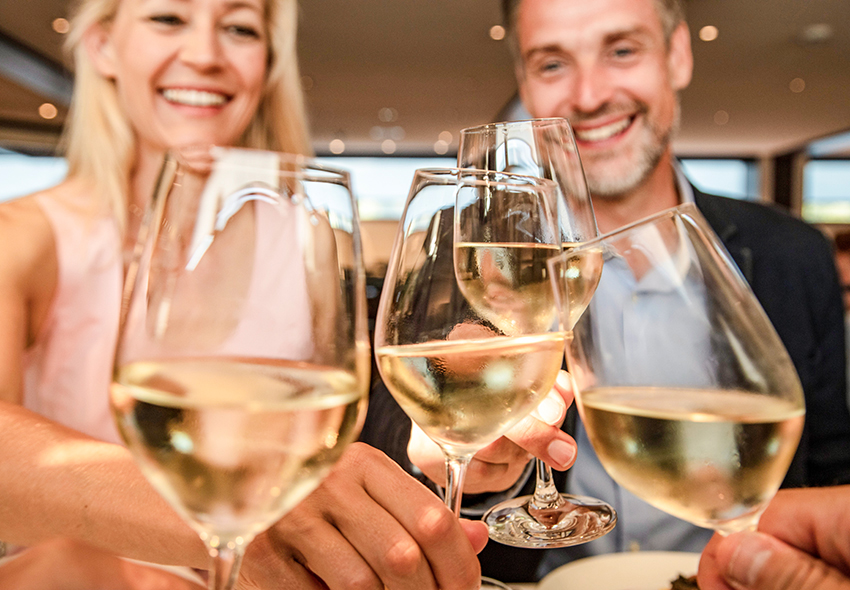 nicko cruises Anstossen Wein Frau und Mann stoßen an Bord von nicko cruises mit Wein an