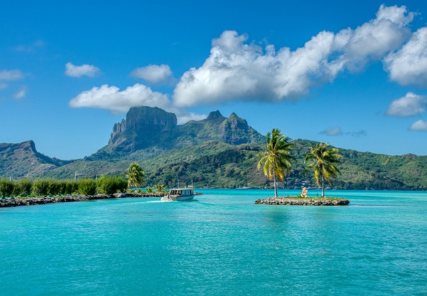 Traumreiseziel Bora Bora Natur Türkisfarbenes Wasser, grüne Palmen, Berge im Hintergrund