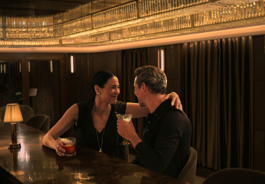 Ein Paar trinkt leckere Cocktails in stilvollem Ambiente und warmen Licht