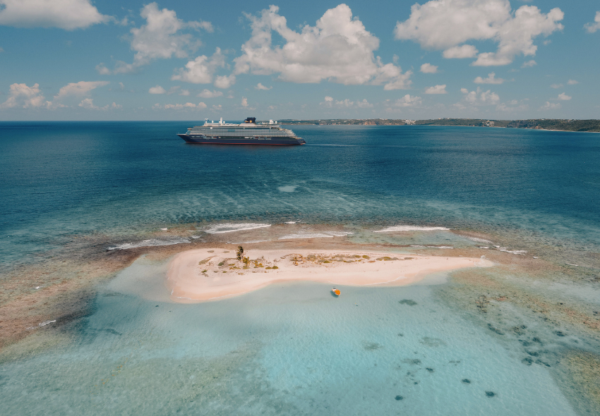 Karibik-Saison Explora Journeys Die EXPLORA III steht im Meer vor einer karibischen Insel
