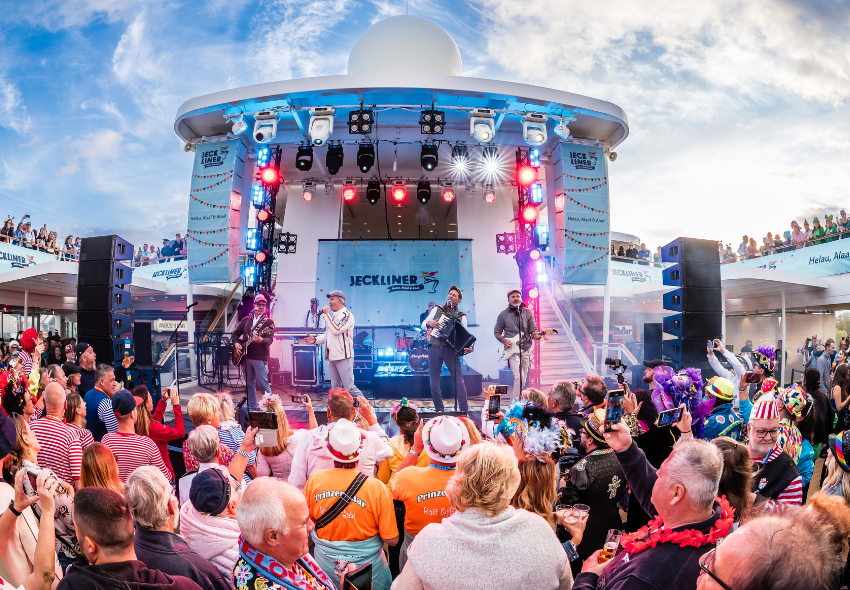 Tanzende Leute blicken auf die Festivalbühne