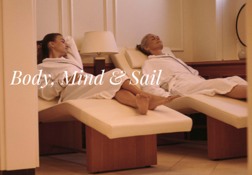 Body, Mind & Sail Zwei Frauen liegen auf Liegen im Spa-Bereich der Sea Cloud Spirit, der Slogan Body, Mind & Sail steht in weiß obendrüber