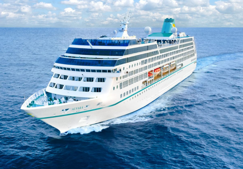 MS Alvara – neues Kreuzfahrtschiff von Phoenix Reisen ab 2027 Visualisierung der MS Alvara von Phoenix Reisen auf dem offenen Meer. Das weiße Kreuzfahrtschiff mit türkisfarbenem Schornstein und türkisfarbener Zierlinie fährt durch blaues Wasser. Die Aufnahme zeigt das Schiff schräg von vorne, mit mehreren Passa