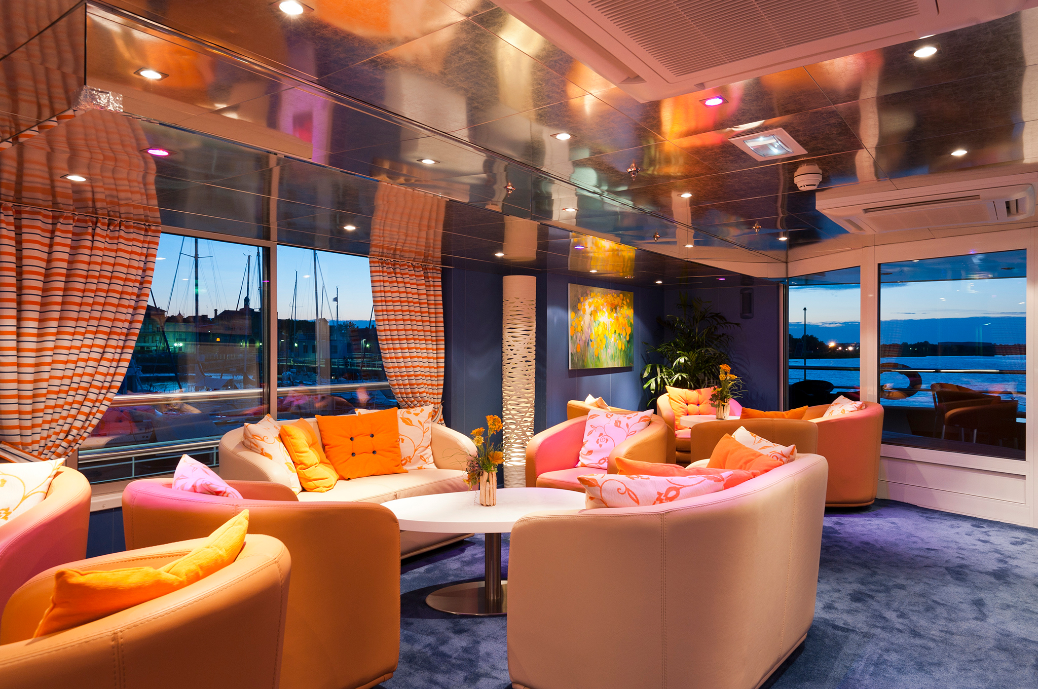 Pianoramabar im oberen Lounge-Bereich der MS CYRANO DE BERGERAC mit großzügigen Panoramafenstern, Sitzgelegenheiten und entspannter Atmosphäre mit Klaviermusik