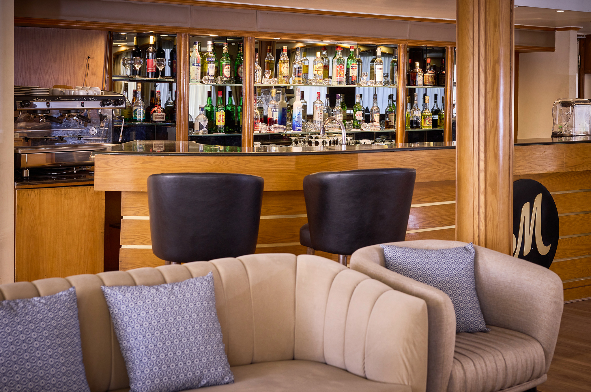 Barbereich in der Lounge der MS Monte Carlo mit stilvollen Sitzgelegenheiten und gemütlicher Atmosphäre
