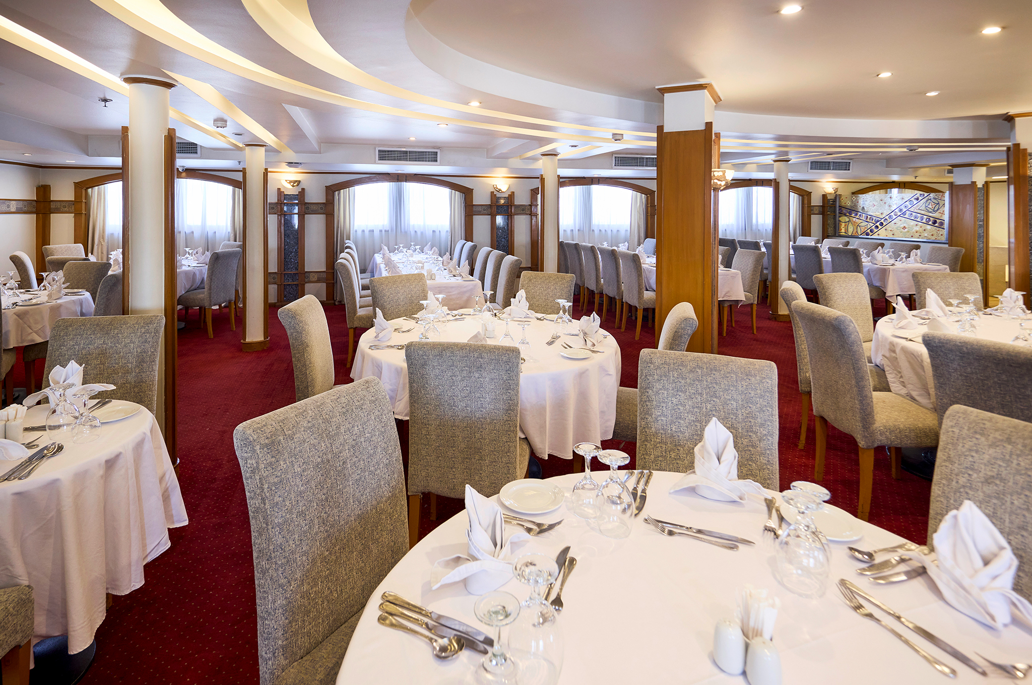 Elegantes Restaurant der MS Monte Carlo mit stilvoll gedeckten Tischen und angenehmer Atmosphäre