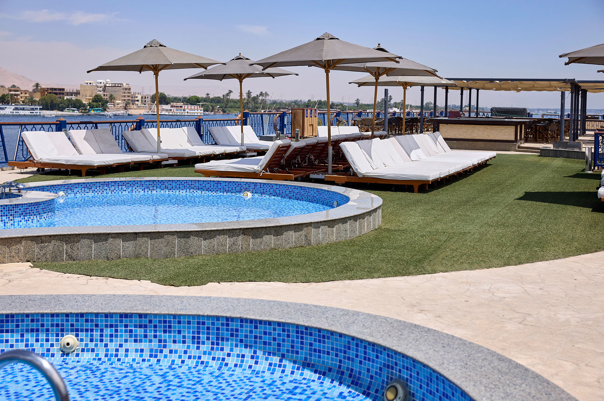 Pool auf dem Sonnendeck der MS Monte Carlo mit Liegestühlen, Sonnenschutz und Sitzbereich zum Entspannen während der Flusskreuzfahrt