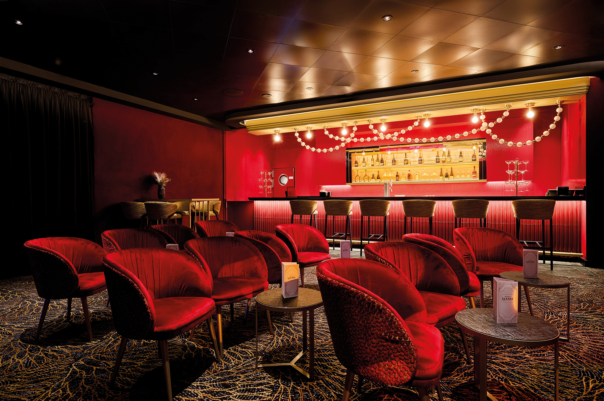 Interior view of La Cage- Casino&Bar&Burlesque on Mein Schiff Flow with bar and seating area.