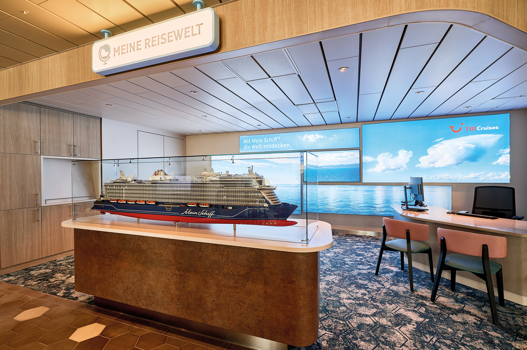 Modell der Mein Schiff Flow im Reisebüro der TUI Cruises unter dem Schild Meine Reisewelt.