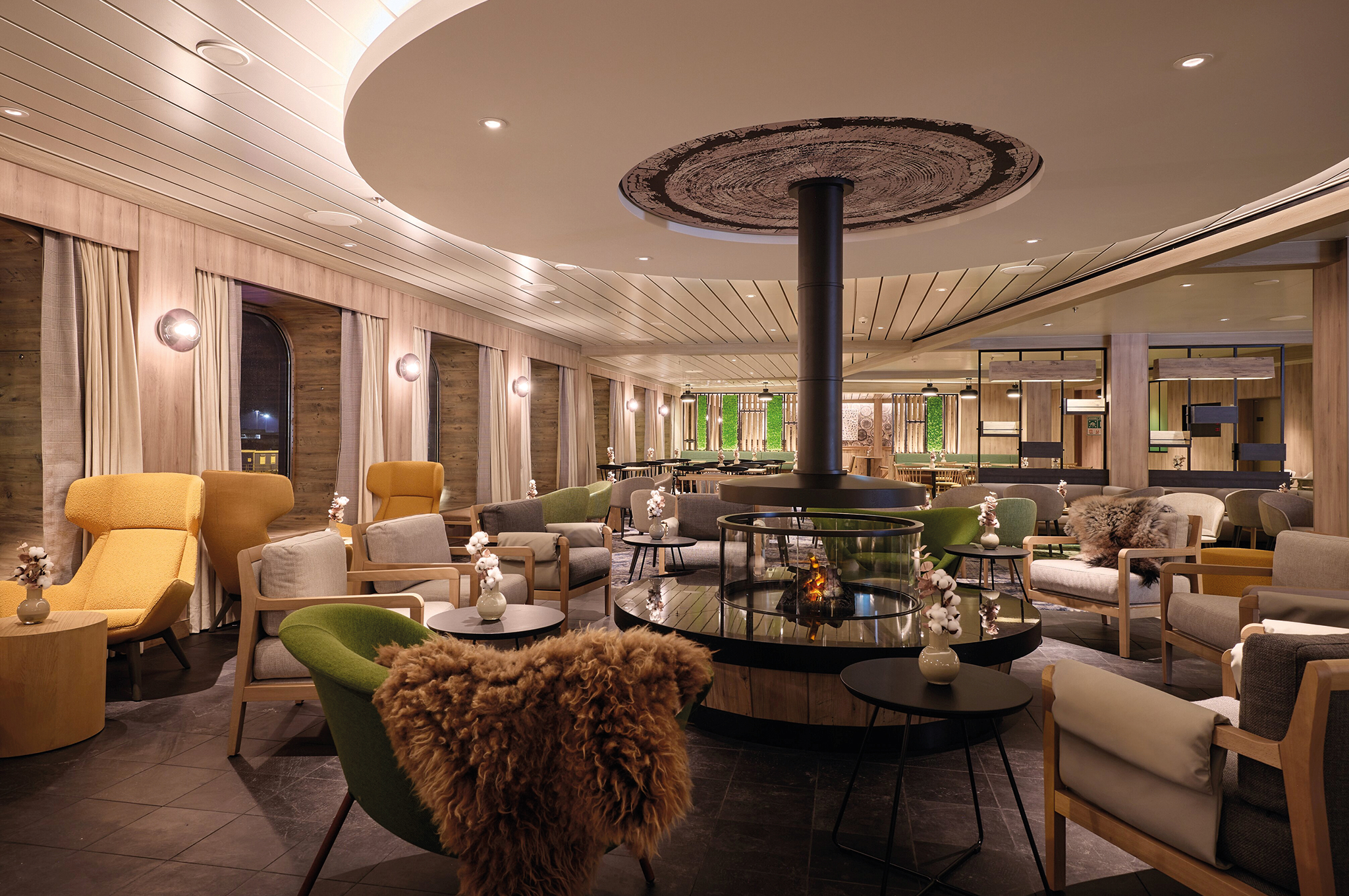 Gemütliche Sitzgruppe mit Kamin im Chalet Restaurant der Mein Schiff Flow.